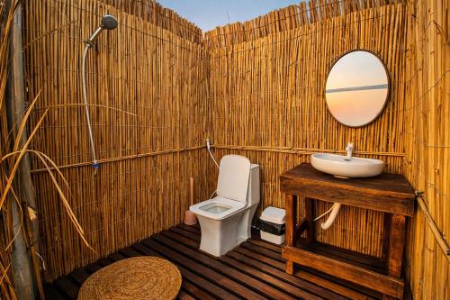 a bathroom with a sink and a toilet and a mirror at Ocean Camp in Al Qārin