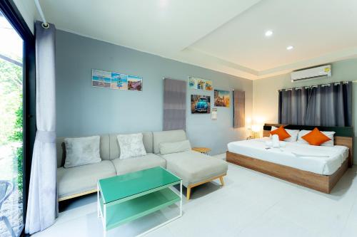 a living room with a couch and a table at Malinee Resort in Bang Tao Beach