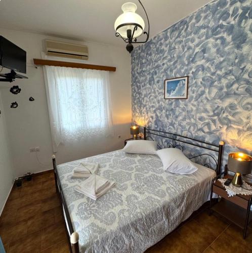 ein Schlafzimmer mit einem Bett und einer blauen Wand in der Unterkunft Καμέλια 3 in Fiskardo