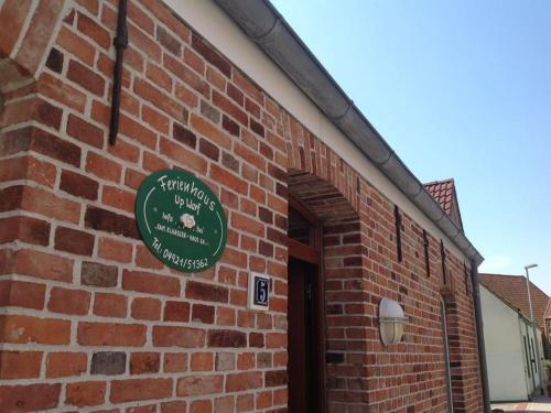 a brick building with a green sign on it at Klaassen- Ferienhaus Up Warf in Emden