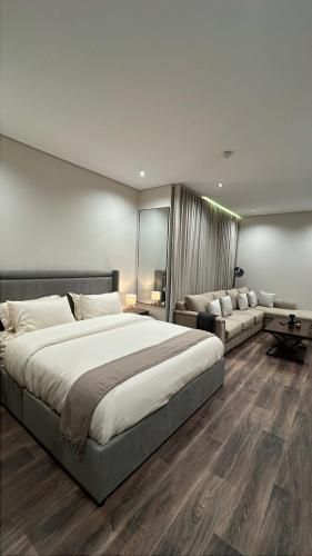 a large bedroom with a large bed and a couch at استديو in Al Khobar