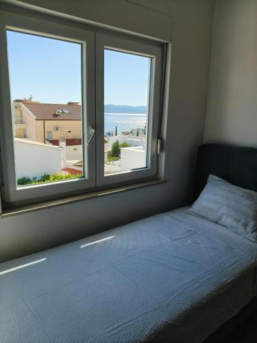 a bedroom with a bed and a window with a view at Apartments Malou in Baška Voda