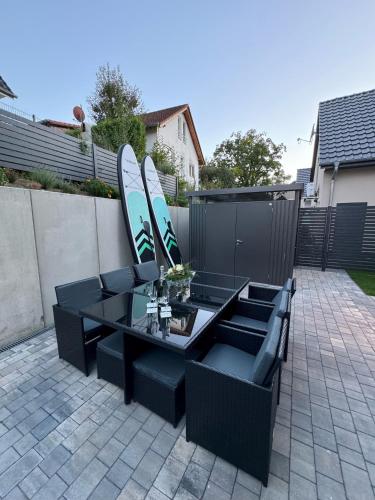 a table and chairs with surfboards on a fence at Strandhaus Marie-Team in Göhren-Lebbin