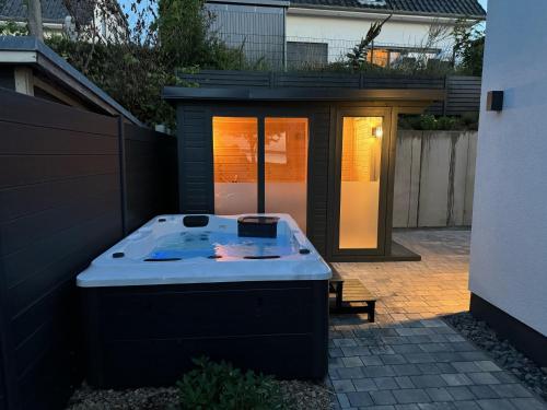 a hot tub in a backyard with a fence at Strandhaus Marie-Team in Göhren-Lebbin