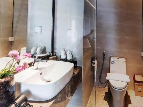a bathroom with a white sink and a toilet at Pristine Coast Residences in Phan Thiet