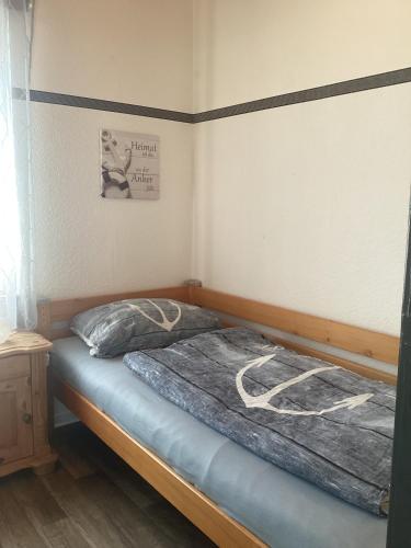 a bedroom with a bed with a blue blanket on it at Ferienhaus Ankerplatz in Bedekaspel