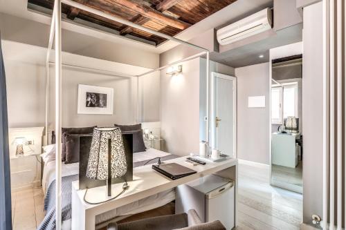 a bedroom with a bed and a desk with a lamp at Hotel Clitunno in Spoleto