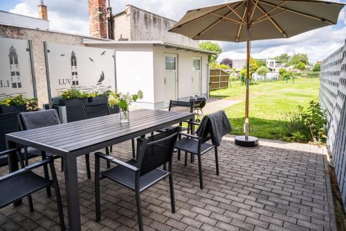 a patio with a wooden table and chairs and an umbrella at Fh "luv" in Ueckermünde