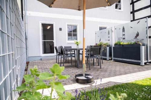 a patio with a table and chairs and an umbrella at Fh "luv" in Ueckermünde