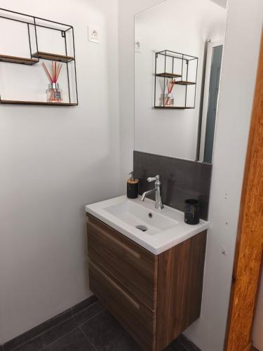 a bathroom with a sink and a mirror at La maison du 116 in Gravelines