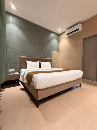 a bedroom with a large bed in a room at Shelter Suites - Formerly known as Fisco The Hub Link in Mumbai
