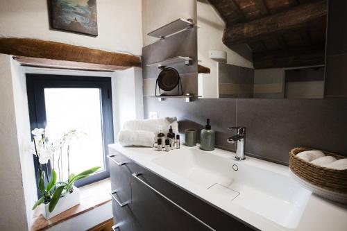 a bathroom with a white sink and a window at Casolare Brindavan Dimora Artemisia in Vaccareccia