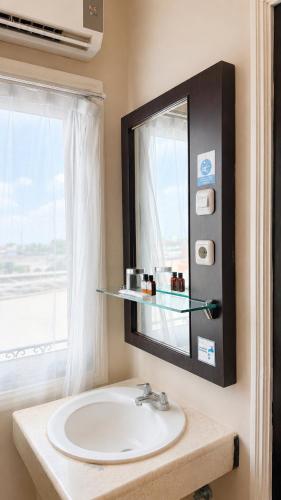 a bathroom sink with a mirror and a window at Kangen Boutique Hotel in Yogyakarta