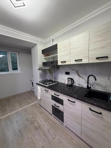 an empty kitchen with wooden cabinets and a sink at Apartament Rîșcani in Chişinău