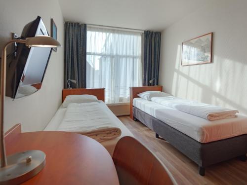 a hotel room with two beds and a table at A-Train Hotel in Amsterdam