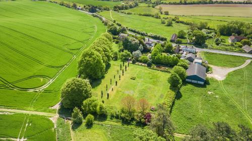 an aerial view of a house in a green field at West Kennett House in Marlborough