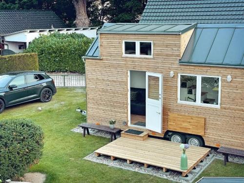 a tiny house in a yard with a car at TINY HOUSE FLEESENSEE mit eigenem Garten und nur wenige Meter vom Seeufer in Unter Göhren