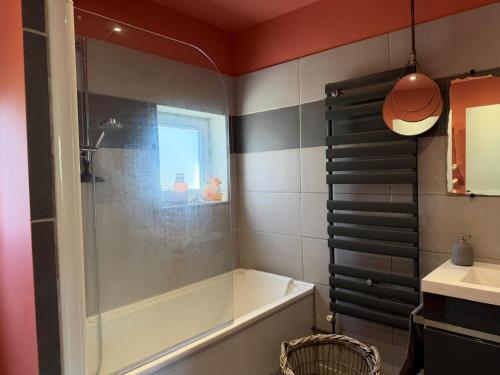 a bathroom with a bath tub and a sink at Maison semi individuelle avec jardin in Ambleteuse