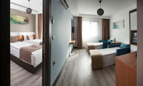 a hotel room with two beds and a living room at Buca Residence Hotel in İzmir