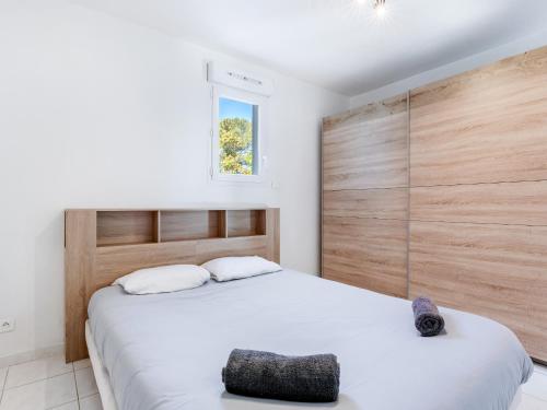 a bedroom with two beds and a wooden wall at Le PTIT VENT, cosy et bien situé in Cavalaire-sur-Mer