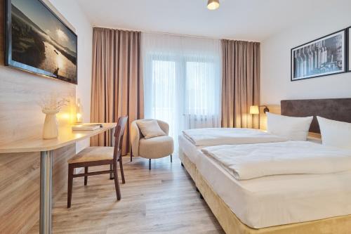 a hotel room with a bed and a desk at Hotel und Weingut Karlsmühle in Mertesdorf
