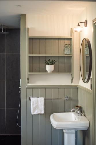a bathroom with a sink and a mirror at Blacksheep Cottage in Oban