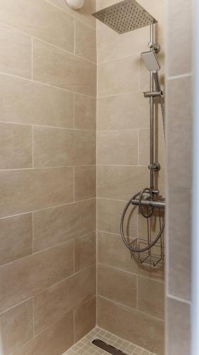 a shower with a shower head in a bathroom at Le PTIT VENT, cosy et bien situé in Cavalaire-sur-Mer