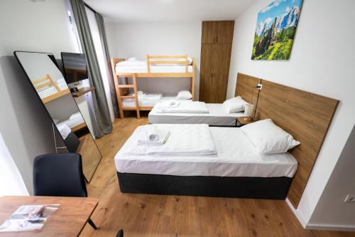 a hotel room with two beds and a table at Apartmani Narona in Jablanica