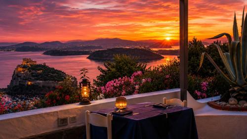 a dining table with a view of a sunset at Barracuda Suite Sea View & Dinner Experience in Ischia Town