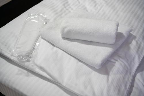 a stack of towels on a white bed at Apartmani Narona in Jablanica