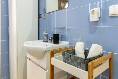 a bathroom with a sink and blue tiles at Family House in Aveiro