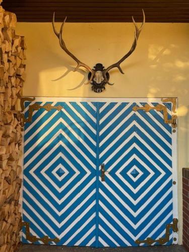 a blue and white door with antlers on a wall at Eisvogel- Ferienwohnung in Marienfelde