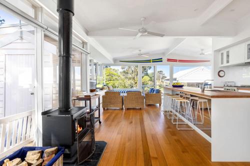 a kitchen and living room with a wood stove at Parkview Cottage Portsea in Portsea