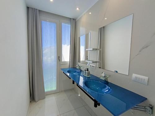 a bathroom with two blue sinks and a large mirror at Villa Luxury Paradise Suites in Salobreña