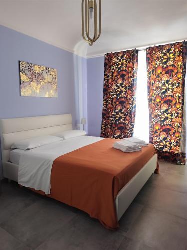 a bedroom with a bed with two windows with curtains at Le stanze del Corso in Monreale