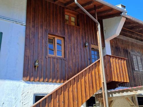 a house with a wooden door and a balcony at Ferienwohnung Sunseid n in Warngau