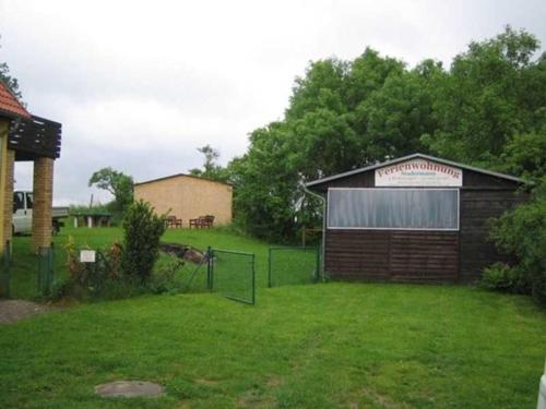 a building with a fence in a yard at Ferienwohnung am Kreßinsee in Strietfeld