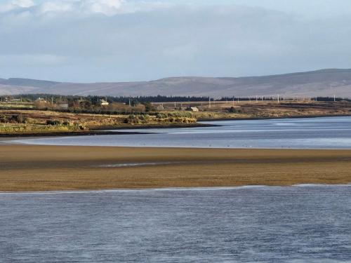 a body of water with mountains in the background at Townhouse Sleeps 8 - Garden Wifi Free Parking in Belmullet