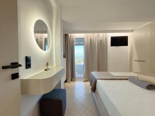 a bedroom with a bed and a sink and a mirror at Alex Apartment Suites in Virós