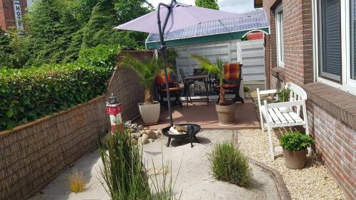 a patio with a table and an umbrella and some plants at Bastan - Haus Katharina in Emden