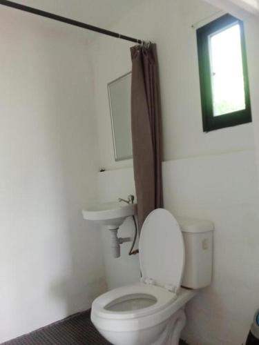 a bathroom with a white toilet and a sink at MountainSide Lodge in El Nido