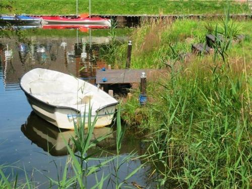 a boat sitting in the water next to a dock at Ferienwohnung Biesterfeld in Bedekaspel