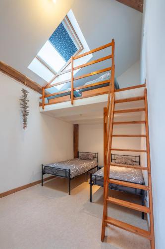 a room with two bunk beds and a ladder at Grand Loft avec Billard Netflix et Climatisation in Socourt