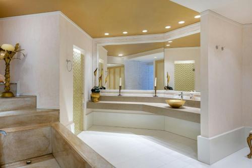a bathroom with a large sink and a large mirror at Grand Hotel Las Dunas, Autograph Collection in Estepona
