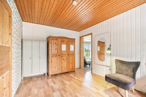 a room with a chair and a wooden ceiling at Ferienwohnung Saustrup in Saustrup