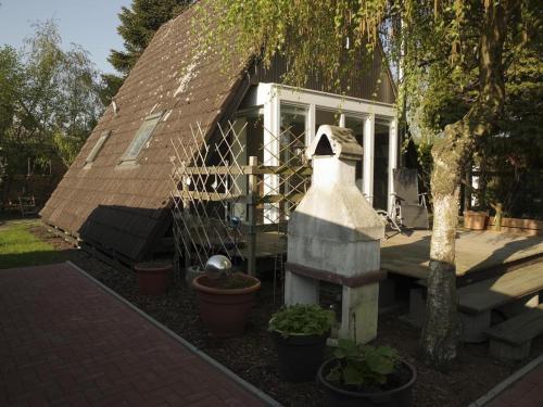 a house with a fence and a yard with plants at Ladwig - Ferienhaus Adda in Südbrookmerland