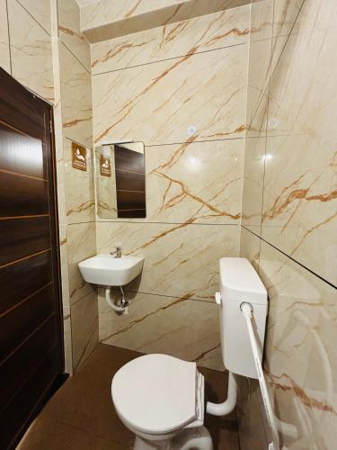 a bathroom with a toilet and a sink at Fort Grande INN in Fort Kochi