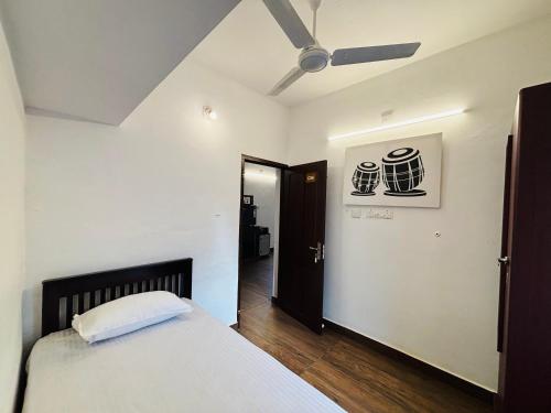 a bedroom with a bed and a ceiling fan at Fort Grande INN in Fort Kochi