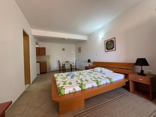 a bedroom with a large bed and a kitchen at SS Pearl Apartment 1 in Utjeha