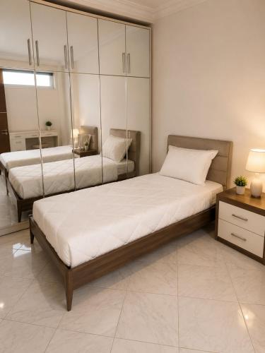 a bedroom with two beds and a mirror at Villa Élégance in Tunis